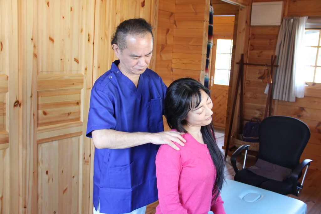 首や肩の状態を確認しながら頭痛の原因をみている施術風景