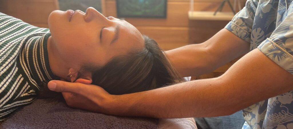 頭部をやさしく支えながら全身のバランスを整える施術風景