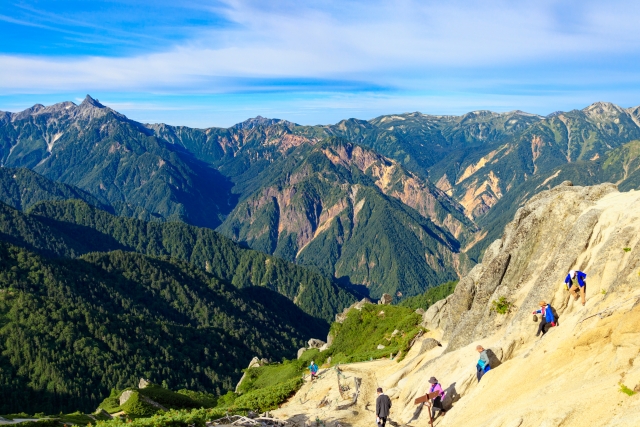 北アルプス燕岳の岩や石が多い登山道を下山する登山者たち
